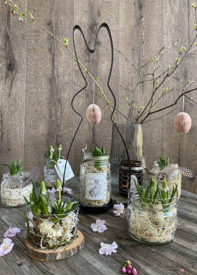 Blumendekoration für Ostern mit leeren Schraubgläsern